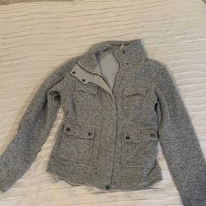 Gray Patagonia zip up with four pockets in the front.